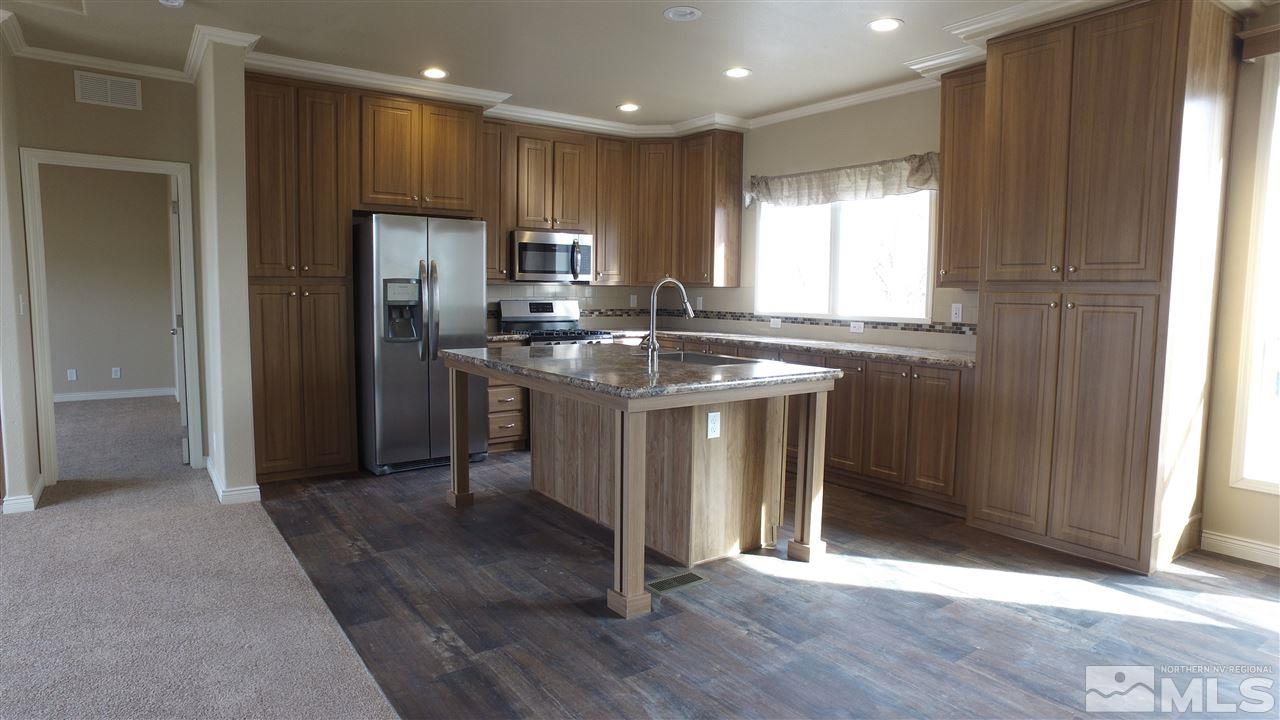 3920 Goldfinch Drive Reno, NV 89508 - Photo 6 of 16 a kitchen with stainless steel appliances granite countertop a stove a refrigerator and a sink
