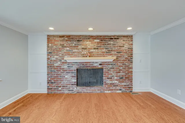 a view of empty room with wooden floor and fireplace