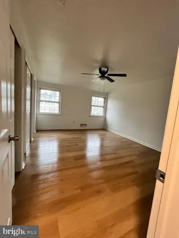 a view of empty room with window and wooden floor