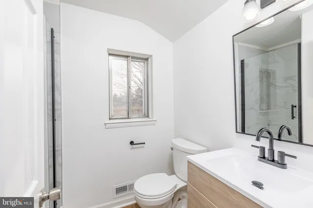 a bathroom with a sink a toilet and mirror