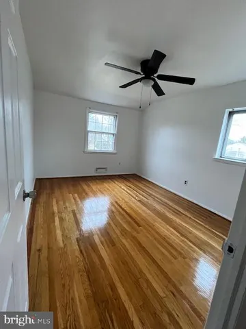 a view of empty room with windows and ceiling fan