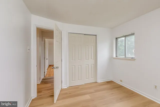 a view of a hallway with wooden floor and closet