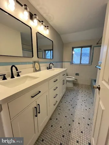 a bathroom with a double vanity sink and mirror
