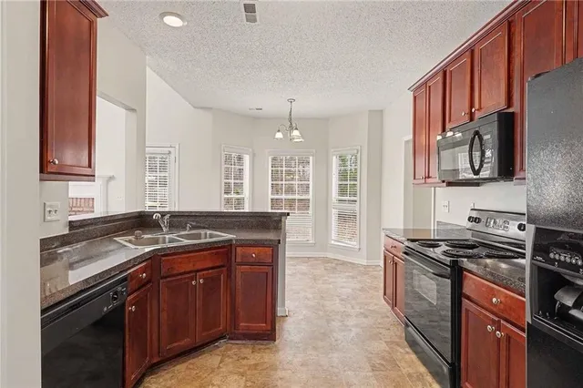 a kitchen with stainless steel appliances granite countertop a refrigerator stove and microwave