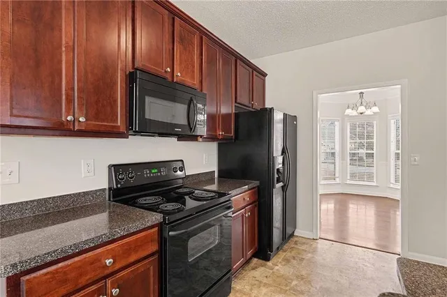 a kitchen with stainless steel appliances granite countertop a stove a sink and a refrigerator