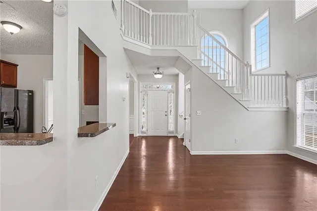 a view of a hallway with wooden floor and staircase