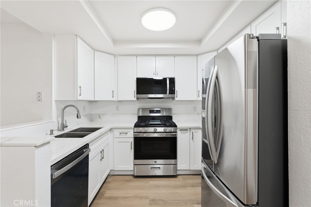15511 Sherman Way, Unit 19 Van Nuys, CA 91406 - Photo 12 of 31 a kitchen with a stove microwave and refrigerator