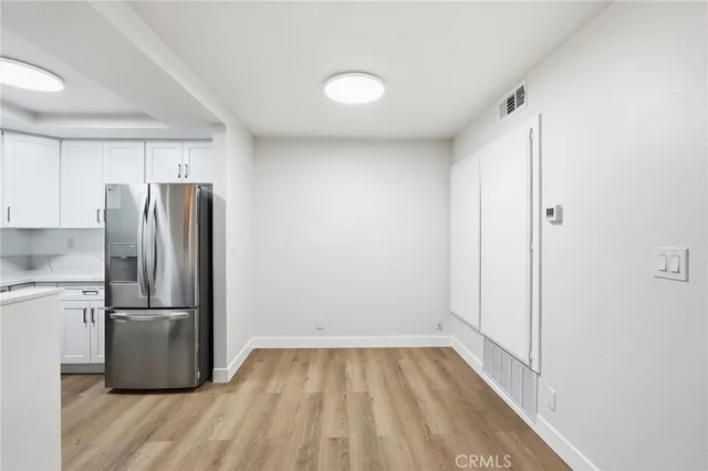 a view of a refrigerator in kitchen and wooden floor