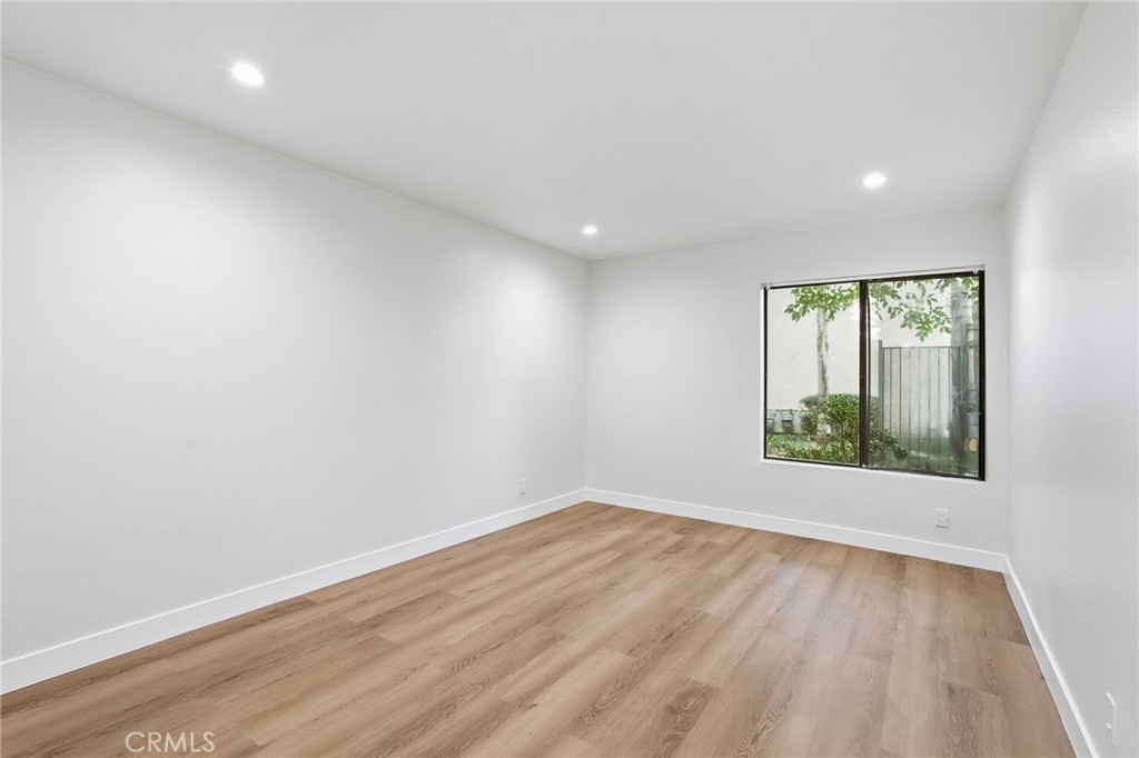 15511 Sherman Way, Unit 19 Van Nuys, CA 91406 - Photo 16 of 31 an empty room with wooden floor and windows
