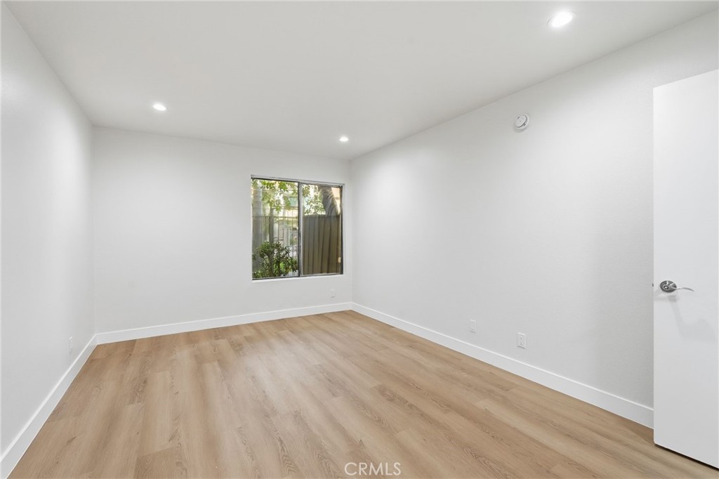 15511 Sherman Way, Unit 19 Van Nuys, CA 91406 - Photo 19 of 31 a view of an empty room with wooden floor and a window
