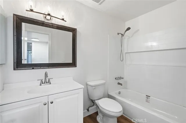 a bathroom with a toilet sink vanity tub and shower
