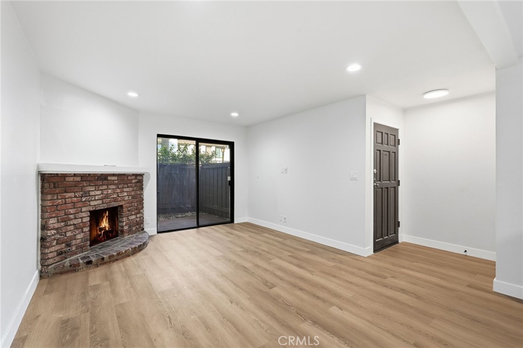 15511 Sherman Way, Unit 19 Van Nuys, CA 91406 - Photo 6 of 31 a view of an empty room with wooden floor fireplace and a window