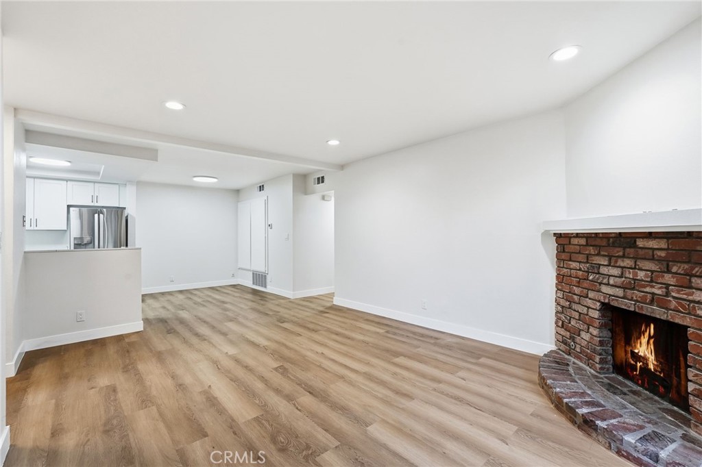 15511 Sherman Way, Unit 19 Van Nuys, CA 91406 - Photo 8 of 31 a view of empty room with wooden floor and fireplace