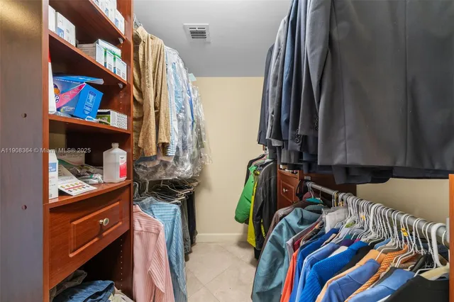 a view of walk in closet with clothes and shoes