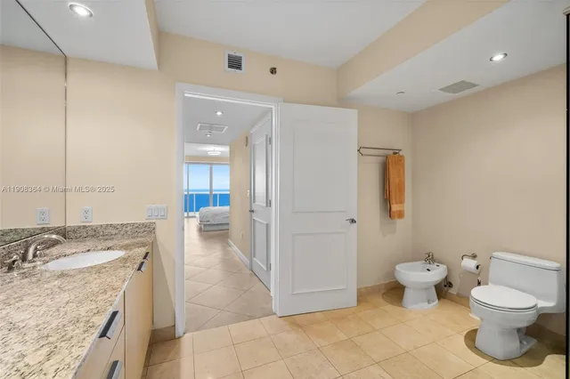 a bathroom with a granite countertop sink a toilet and a tub
