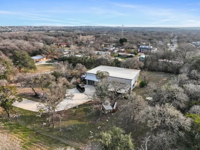 an aerial view of a house with yard and mountain view in back