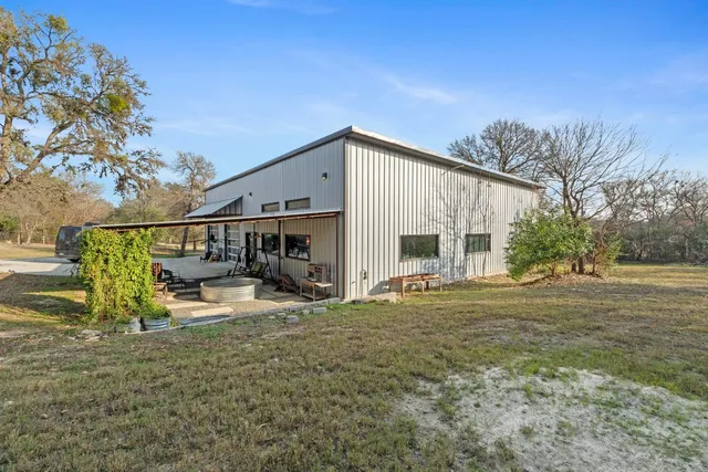 a view of dirt yard with large trees