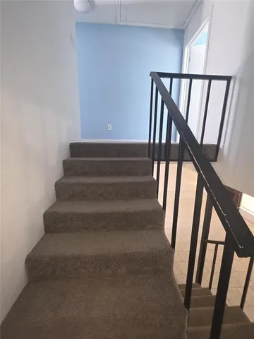 a view of staircase with lots of frames on stairs