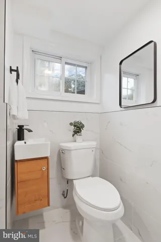 a bathroom with a toilet a sink and a window