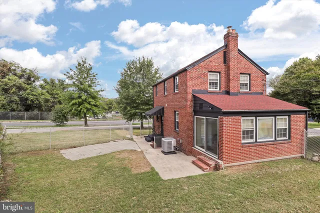 a view of a yard in front of a house with large trees