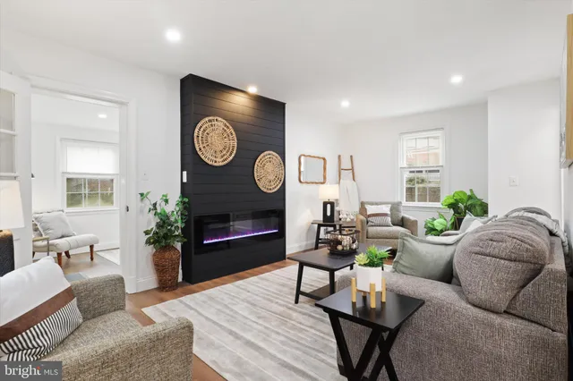 a living room with furniture a clock and a fireplace