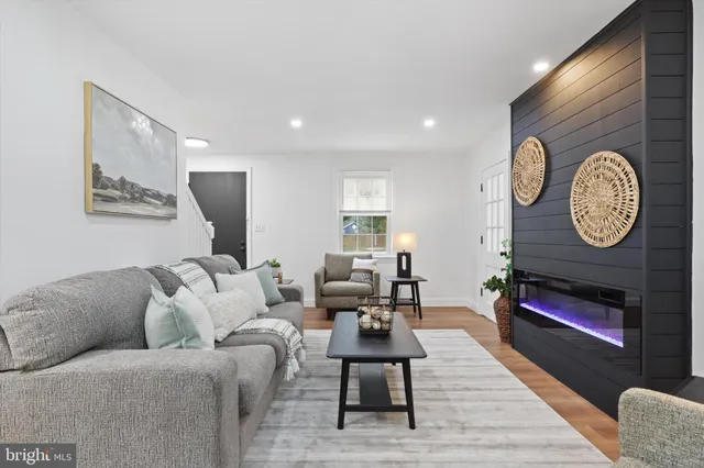 a living room with furniture a clock and a fireplace
