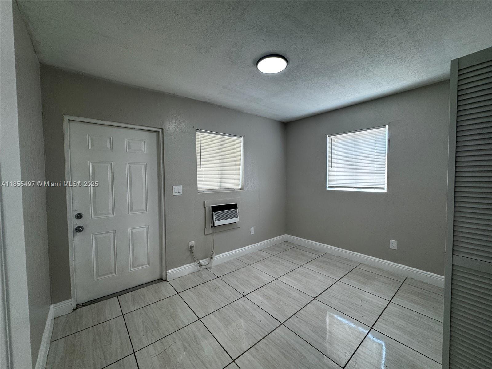 1940 Washington Avenue, Unit 12 Opa-Locka, FL 33054 - Photo 11 of 13 an empty room with windows and closet