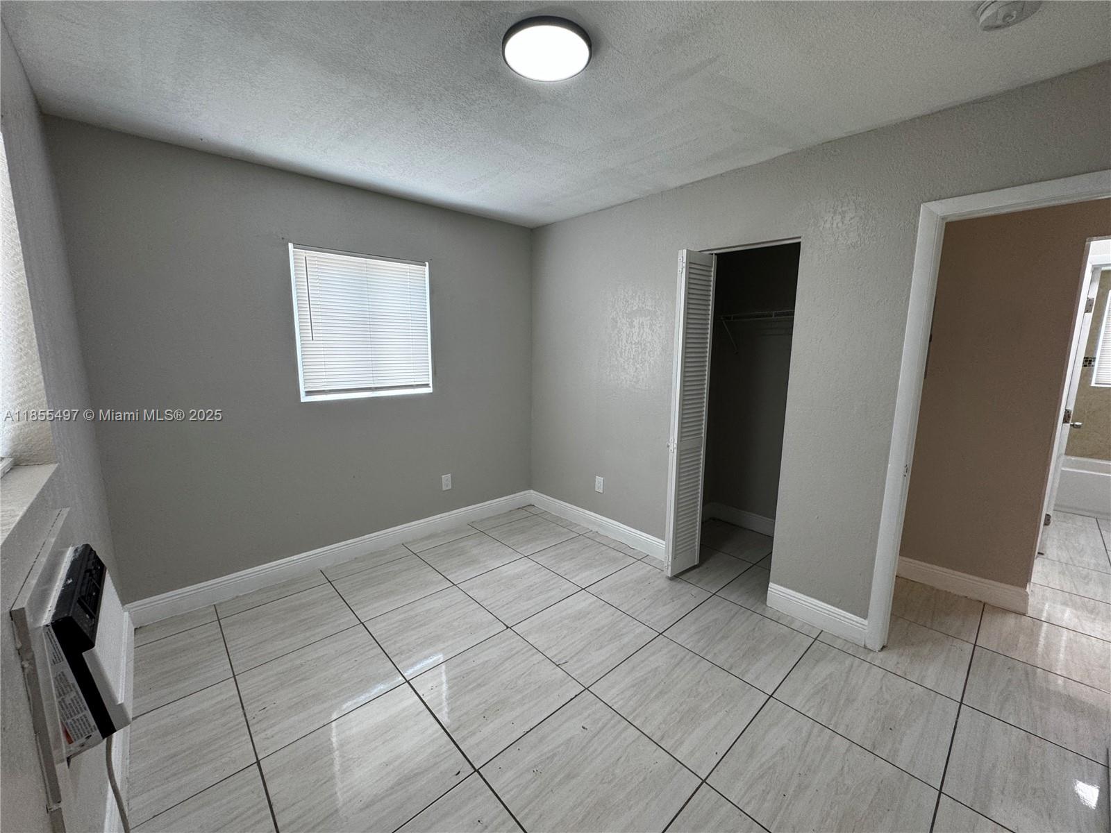 1940 Washington Avenue, Unit 12 Opa-Locka, FL 33054 - Photo 12 of 13 an empty room with windows