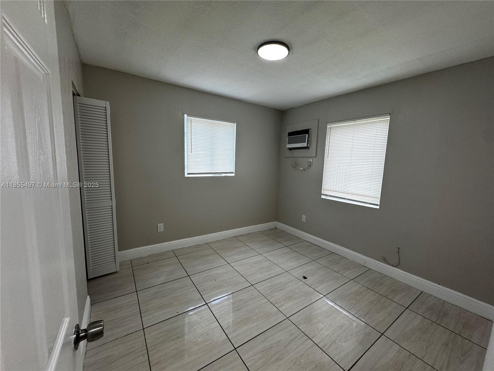 1940 Washington Avenue, Unit 12 Opa-Locka, FL 33054 - Photo 6 of 13 an empty room with windows