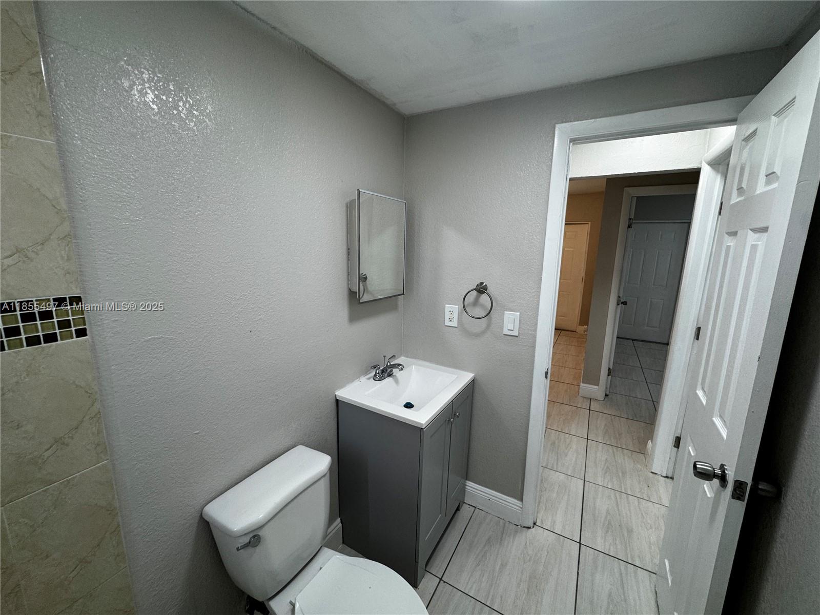 1940 Washington Avenue, Unit 12 Opa-Locka, FL 33054 - Photo 7 of 13 a bathroom with a toilet sink and mirror