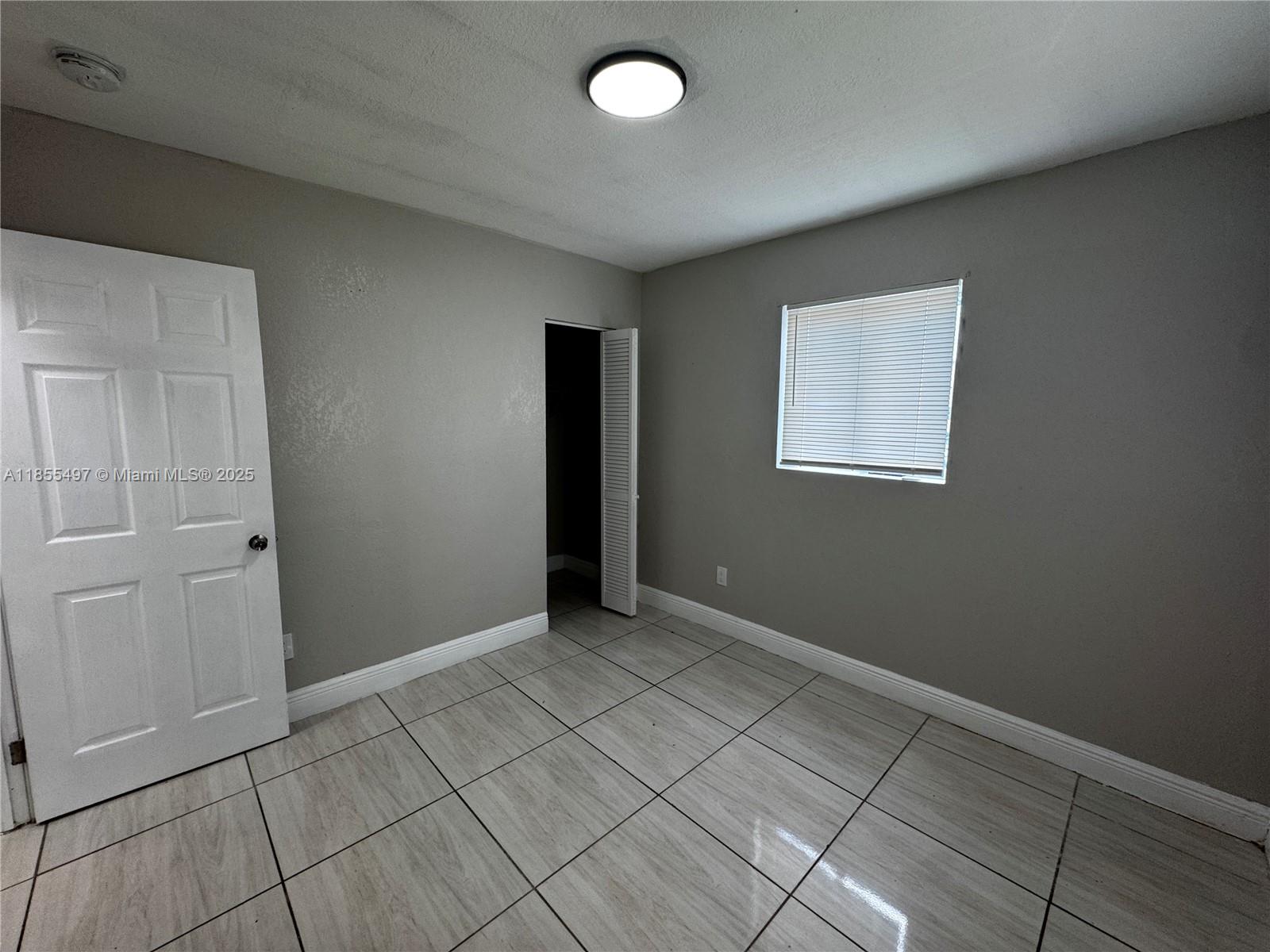 1940 Washington Avenue, Unit 12 Opa-Locka, FL 33054 - Photo 8 of 13 an empty room with windows