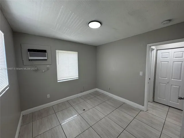 an empty room with windows and closet