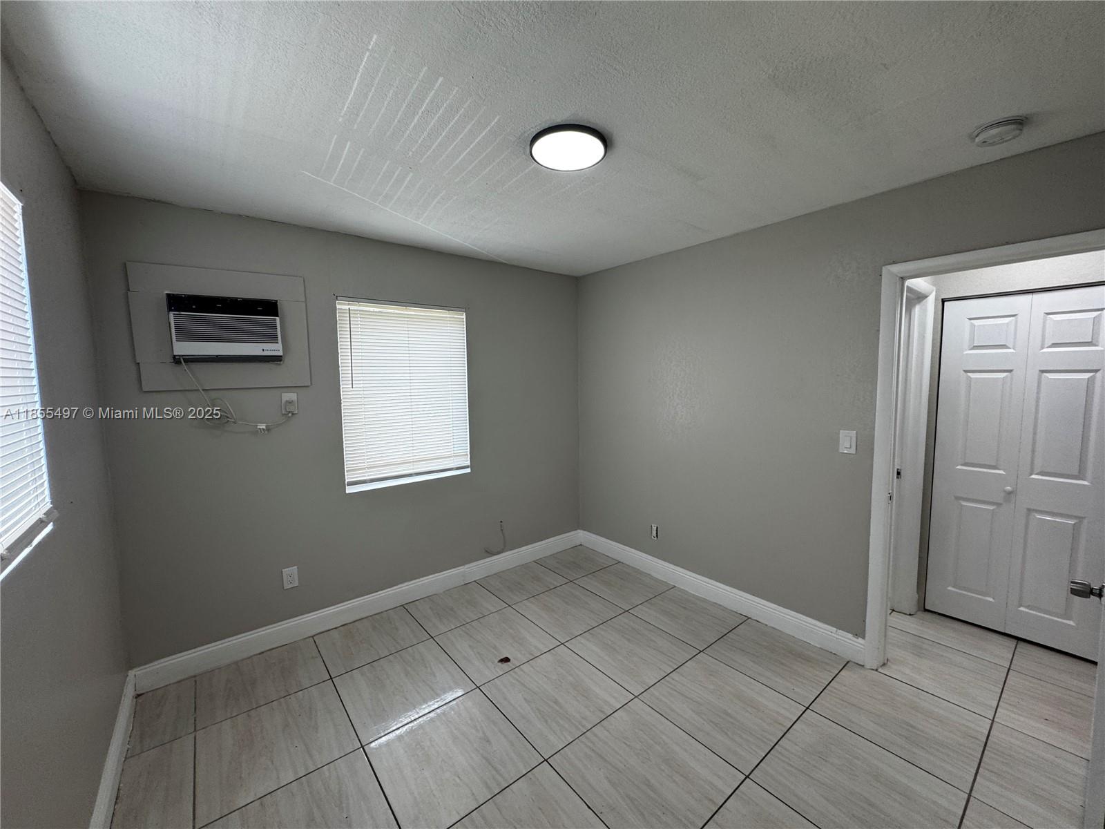 1940 Washington Avenue, Unit 12 Opa-Locka, FL 33054 - Photo 10 of 13 an empty room with windows and closet