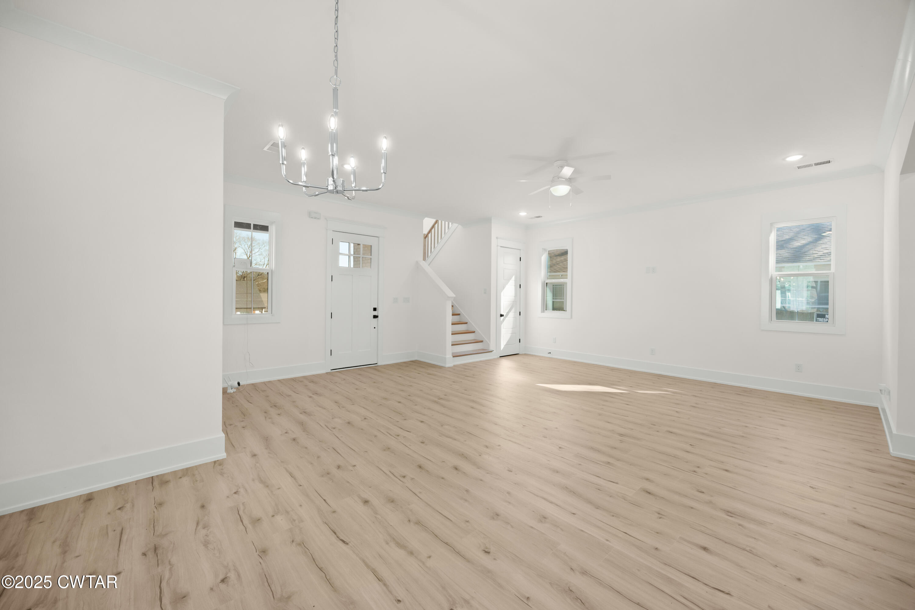 219 Clay Street Jackson, TN 38301 - Photo 3 of 25 a view of an empty room with wooden floor and a chandelier