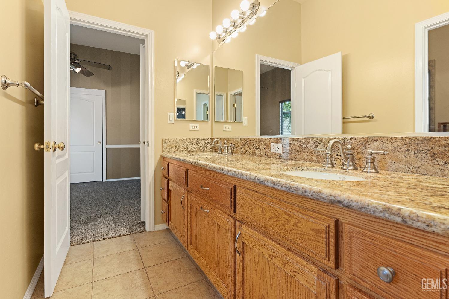 Undisclosed Address Bakersfield, CA 93306 - Photo 23 of 41 a spacious bathroom with a granite countertop sink a mirror and a