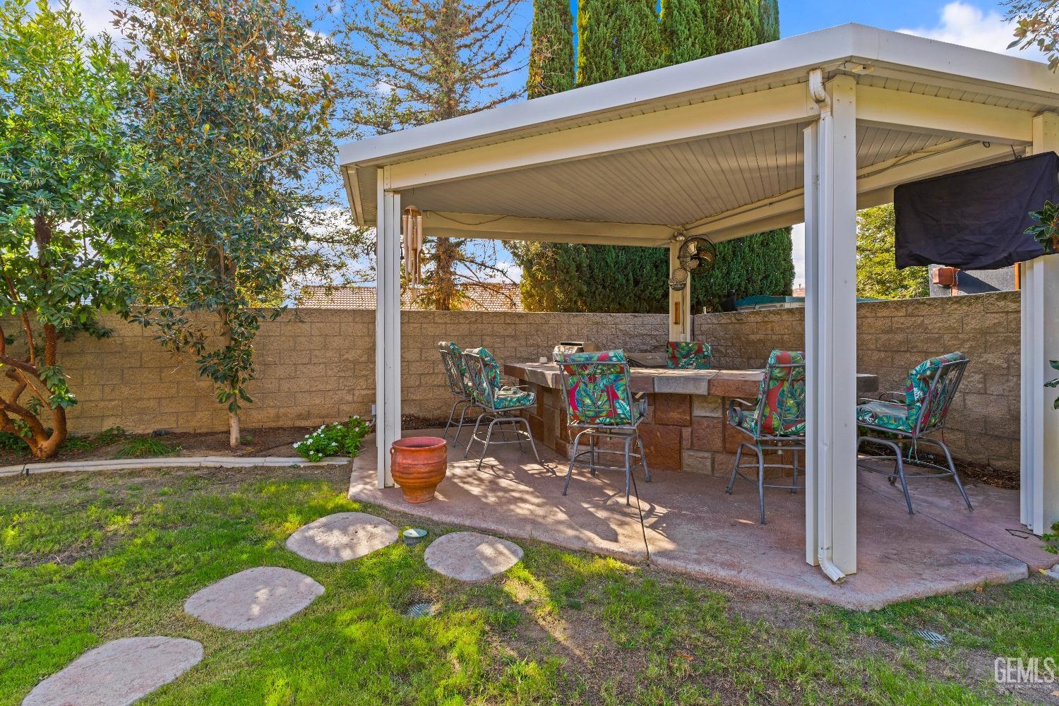 Undisclosed Address Bakersfield, CA 93306 - Photo 34 of 41 a view of a patio with table and chairs potted plants and a large tree