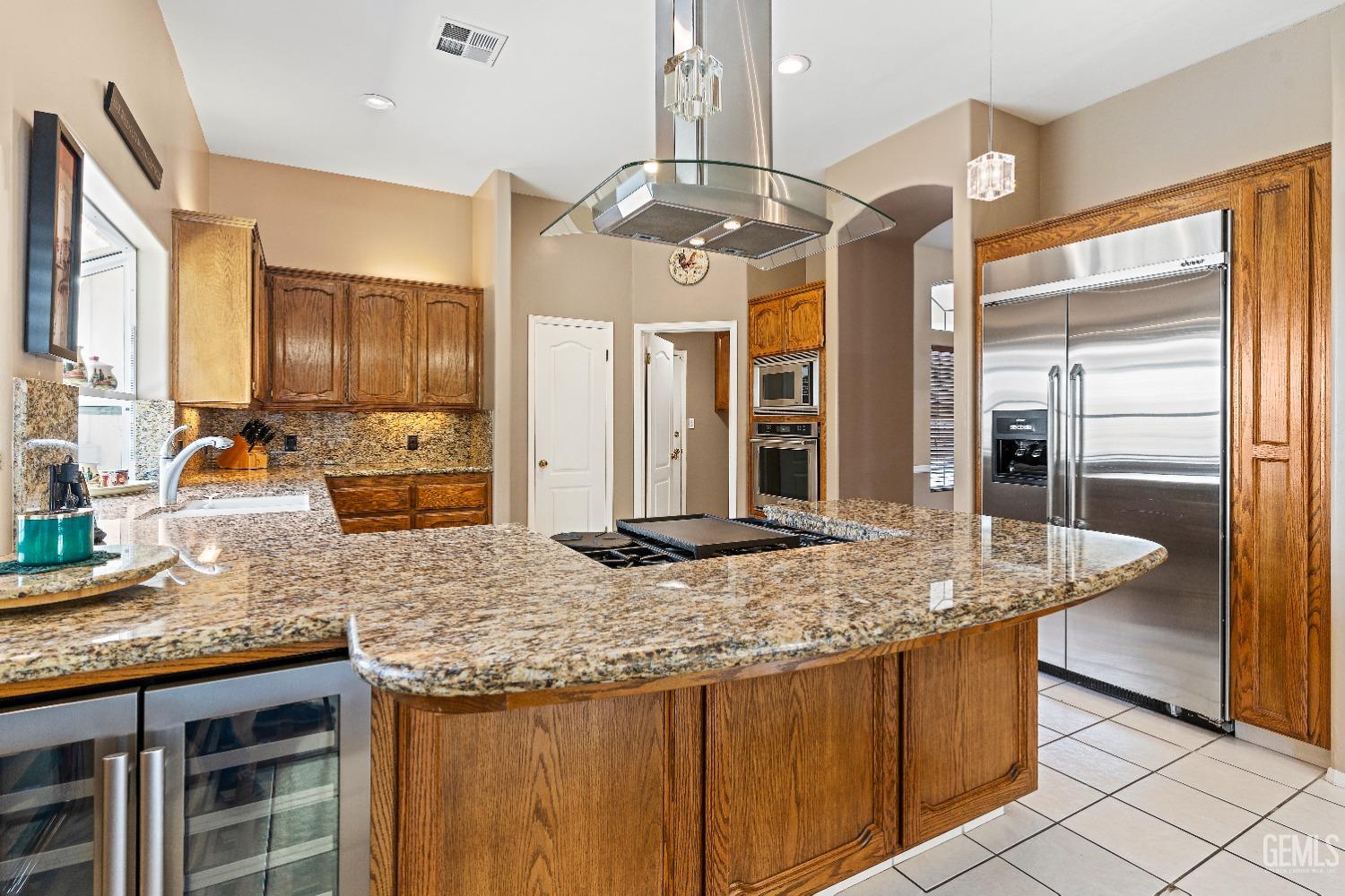 Undisclosed Address Bakersfield, CA 93306 - Photo 7 of 41 a kitchen with granite countertop kitchen island stainless steel appliances a sink stove and refrigerator