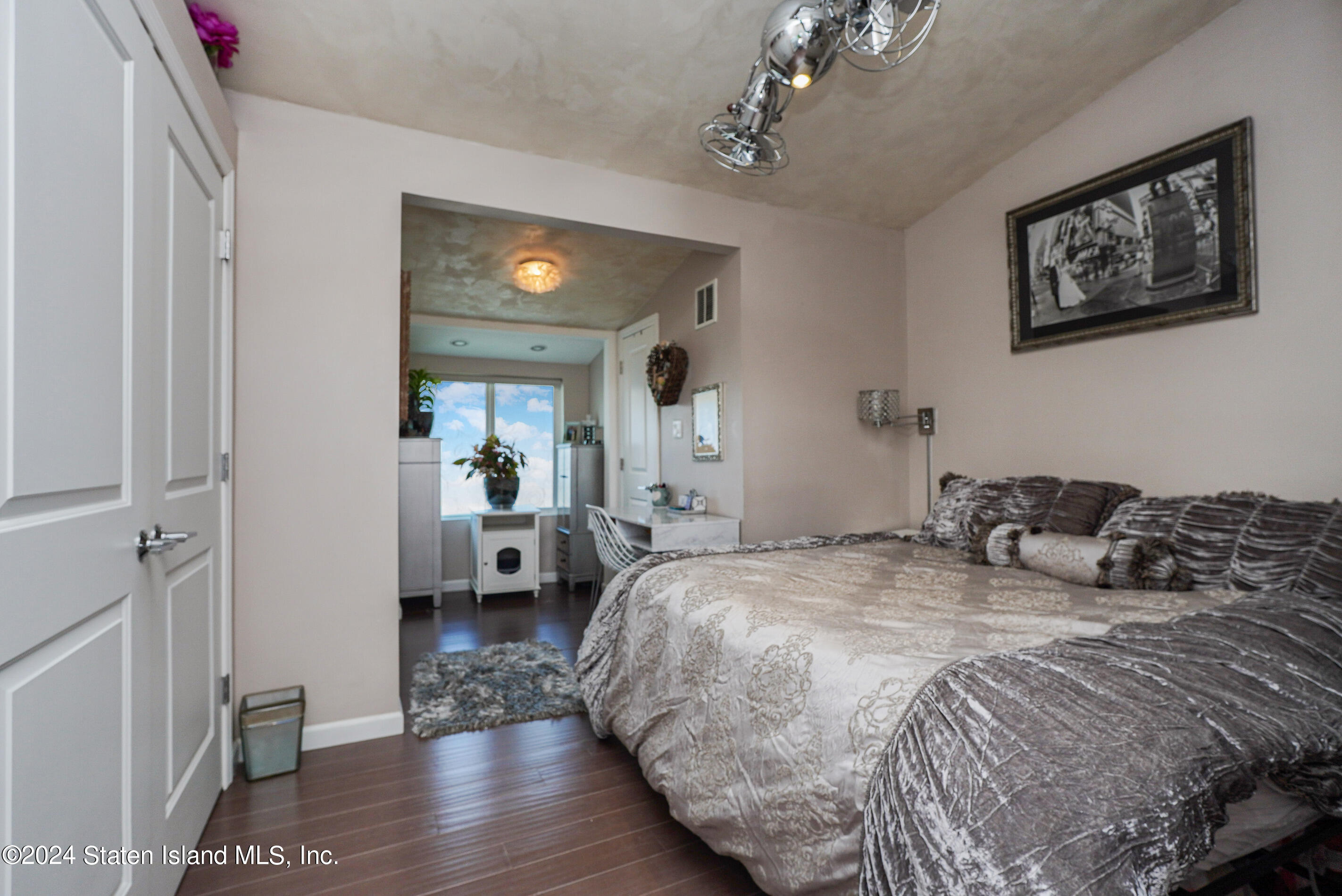 38 Milbank Road Staten Island, NY 10306 - Photo 19 of 30 a bedroom with a large bed a chandelier and closet