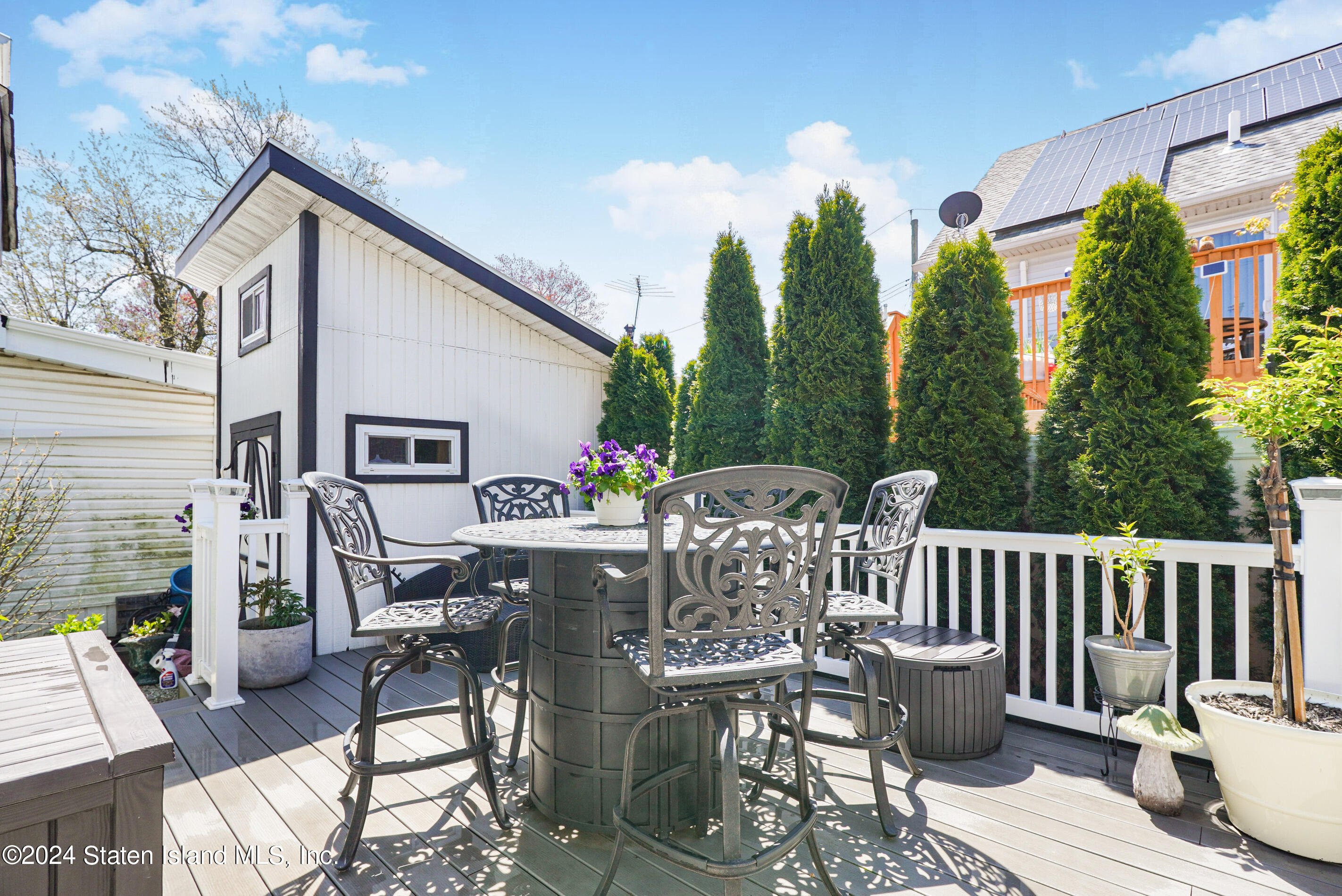 38 Milbank Road Staten Island, NY 10306 - Photo 28 of 30 a view of a patio with a dining table and chairs with wooden floor