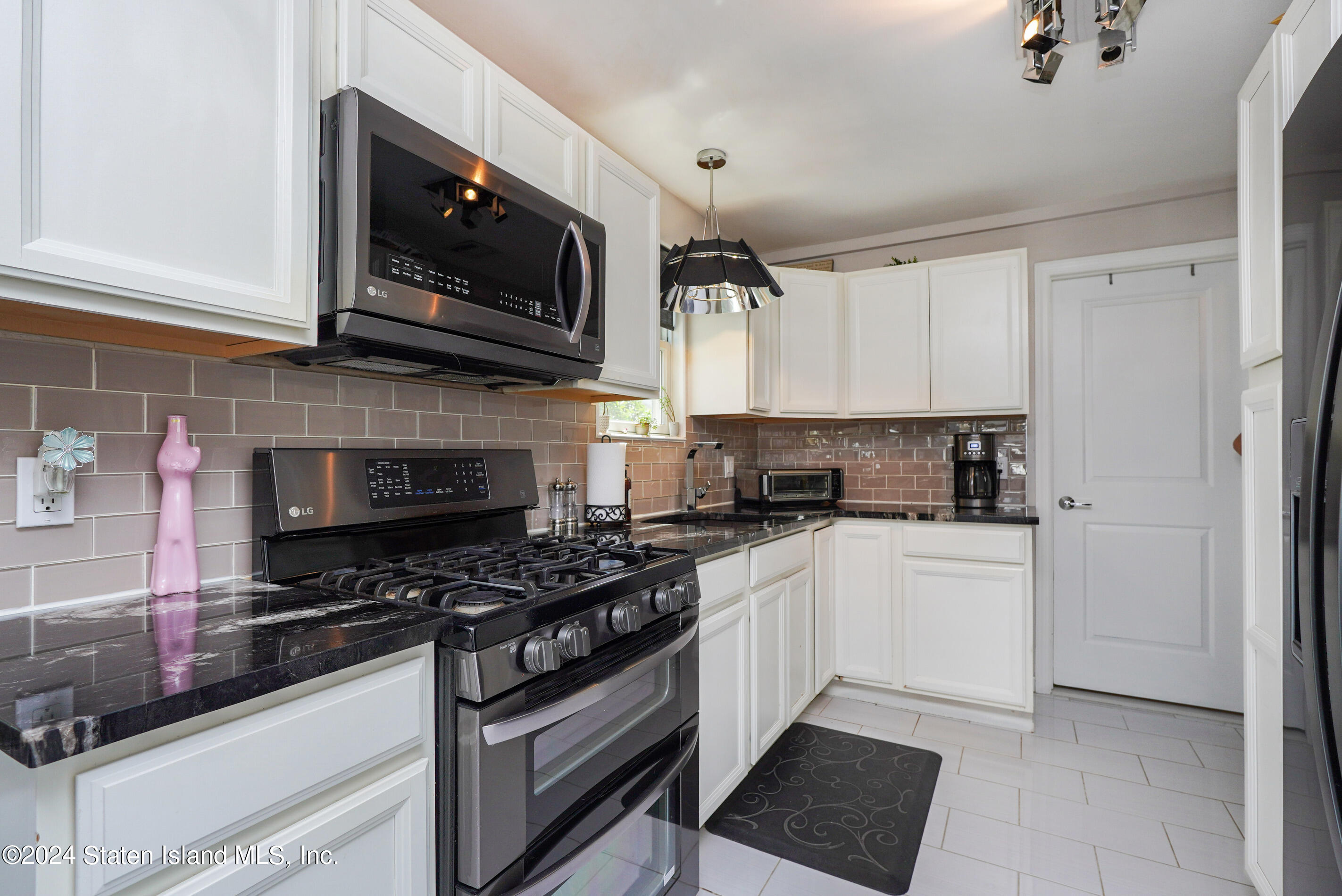 38 Milbank Road Staten Island, NY 10306 - Photo 4 of 30 a kitchen with stainless steel appliances a stove a microwave a sink and cabinets