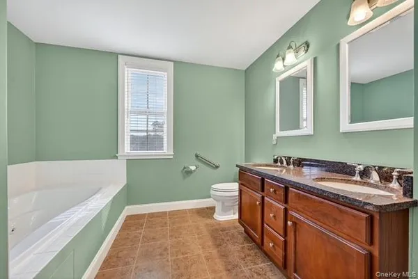 a bathroom with a tub sink and mirror