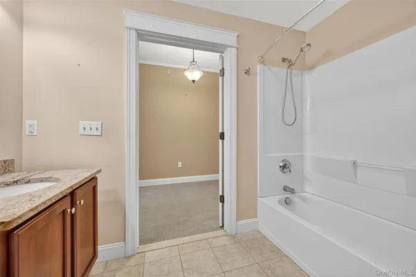 a bathroom with a granite countertop sink a mirror bathtub and shower