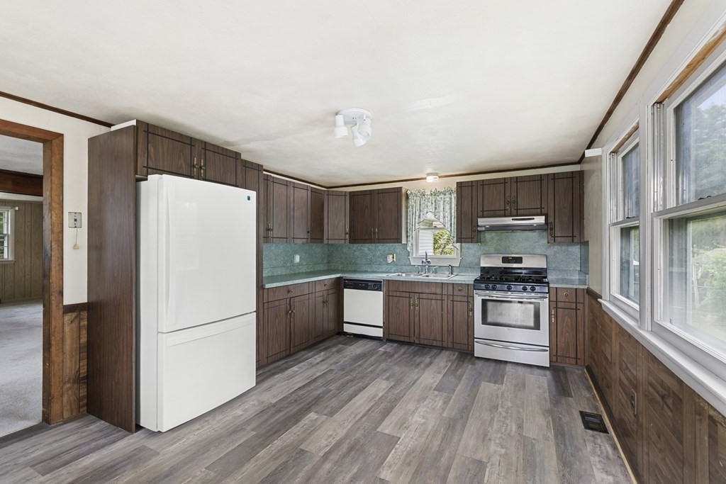 10 Fitzpatrick Avenue Brockton, MA 02301 - Photo 4 of 34 a kitchen with stainless steel appliances granite countertop a refrigerator a stove top oven a sink and dishwasher with wooden floor