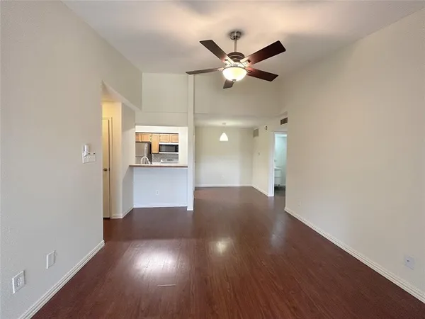 a view of a livingroom with wooden floor and a ceiling fan
