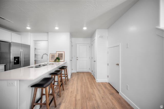 2202 Wolverine Way, Unit 2529 Washington, UT 84780 - Photo 7 of 27 Kitchen island featuring a stainless steel sink, contemporary faucet, and white countertop