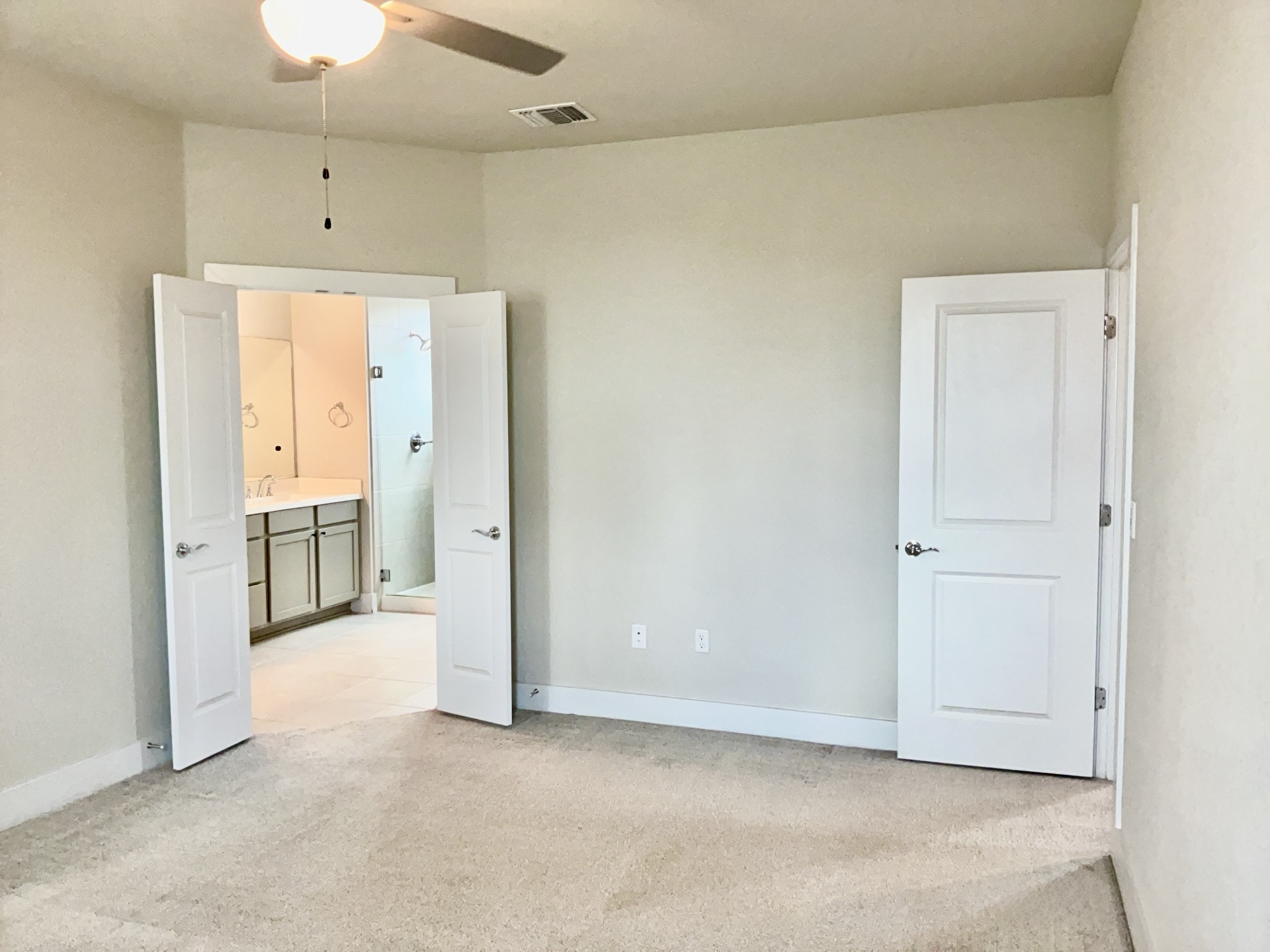 8315 Laughlin Lane Austin, TX 78744 - Photo 10 of 23 Primary bedroom featuring light colored carpet, a ceiling fan, and ensuite bath