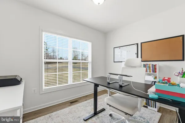 a view of a workspace with furniture and a window