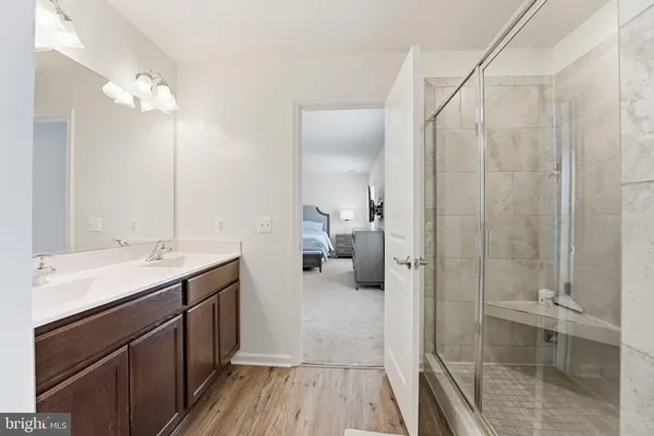a en suite bathroom with a double vanity sink a mirror and shower