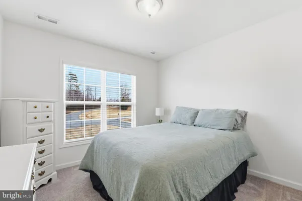 a large bed sitting in a bedroom next to a window