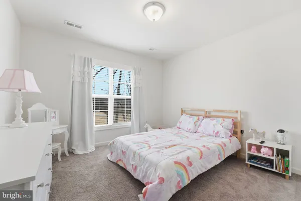 a bedroom with a bed and a dresser in it